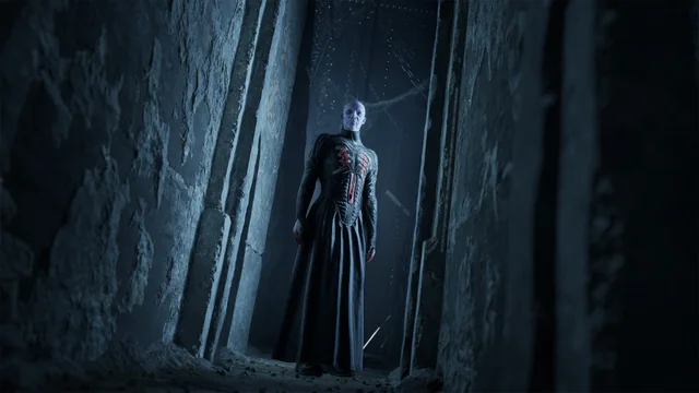 A dark stone corridor in Clive Barker's Hellraiser: Revival with a distant figure standing at the far end.
