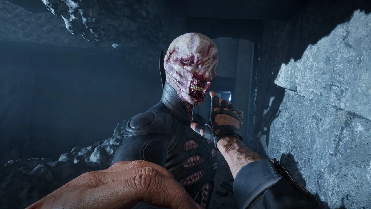 A Cenobite's pale hand and hooked face emerging from shadow in the Labyrinth of Clive Barker's Hellraiser: Revival.